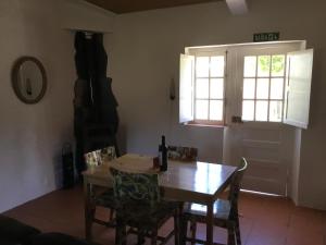 a dining room with a table and chairs and a window at Quinta Boavista in Cercal