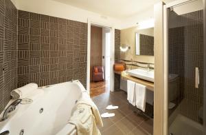 a bathroom with a tub and a sink at Eureka Palace Hotel Spa Resort in Cassibile