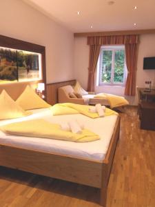 a bedroom with two beds with yellow sheets at Gut Drasing in Krumpendorf am Wörthersee