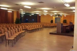 a lecture hall with chairs and a podium and a stage at Eureka Palace Hotel Spa Resort in Cassibile