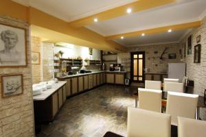 a large kitchen with white chairs in a room at GTM Kapan in Tbilisi City