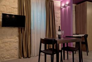 uma sala de jantar com uma mesa com duas cadeiras e uma televisão em Annie's stone Studio & Room em Split