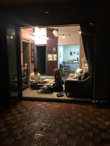 two people sitting on the floor in a living room at Us on Earth Guesthouse in Danyang