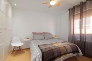 een slaapkamer met een bed met een deken en een raam bij Acera del Darro, céntrico in Granada