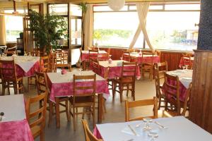 a restaurant with tables and chairs with pink tablecloths at A Muralha in Almeida