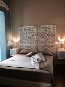 a bed with a basket on top of it at Villa Blanche Dimora Di Charme in Marsala +65 photos