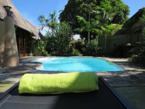 una piscina con una toalla verde al lado en Afrikhaya Guest House, en St Lucia