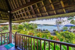 a balcony of a resort with a view of the water at Laguna Reef Huts in Nusa Lembongan