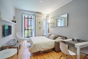 sypialnia z łóżkiem, stołem i krzesłami w obiekcie LEEWAYS LOFT in FUENCARRAL w Madrycie