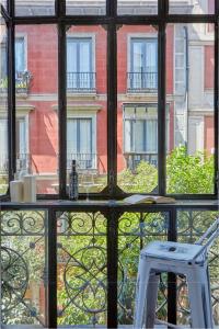 un tabouret blanc assis devant une fenêtre dans l'établissement LEEWAYS LOFT in FUENCARRAL, à Madrid