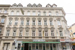 un grand bâtiment avec un panneau à l'avant dans l'établissement Apartment house in Vienna, à Vienne