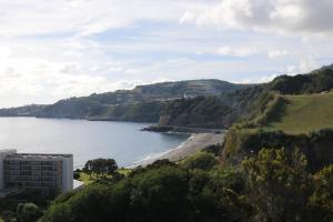 vista sull'oceano e su una spiaggia con un edificio di Cantinho Das Praias a Vila Franca do Campo