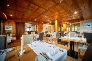 restauracja z drewnianymi sufitami, stołami i krzesłami w obiekcie The Onya Resort & Spa w mieście Bellwald