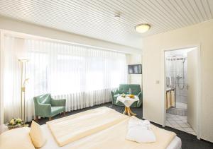 ヘーヘンシュヴァントにあるPortens Hotel Fernblickのベッドルーム1室(ベッド1台、椅子、テーブル付)