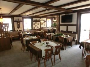 a restaurant with tables and chairs and a flat screen tv at Hotel Glindenberger Hof in Glindenberg