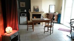 een woonkamer met een tafel en een open haard bij Route de voivres in La Suze-sur-Sarthe