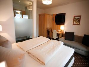 ein Hotelzimmer mit einem Bett und einem Wohnzimmer in der Unterkunft Hotel Diana in Pörtschach am Wörthersee