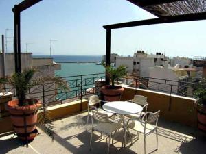 een patio met een tafel en stoelen op een balkon bij Diana Hotel in Chios