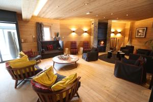 a living room with couches and chairs and a table at Résidence Club mmv Le Cœur des Loges **** in Les Menuires