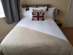 a bedroom with a large bed with pillows on it at Kathleen House Plus in Enfield