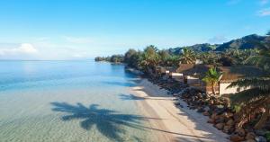 an aerial view of a beach with palm trees and the ocean at Sea Change Villas in Rarotonga