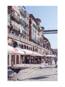a street with tables and umbrellas in a city at Panorama Apartments Ribeira Porto in Porto