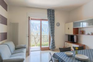 a living room with a table and a couch and a window at Villa Due Leoni - Residence in Brenzone sul Garda