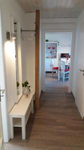 - un couloir avec un miroir et une table dans la chambre dans l'établissement Ferienwohnung Brunnenstrasse, à Bremervörde