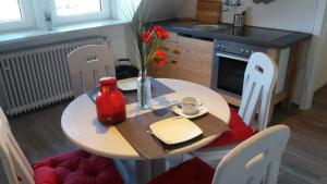 eine Küche mit einem Tisch, Stühlen, einem Tisch und einem Tisch in der Unterkunft Ferienwohnung Brunnenstrasse in Bremervörde