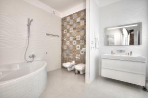 uma casa de banho com uma banheira, um lavatório e um WC. em Union Hotel Prague em Praga