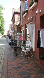 une rue avec des chaises et un panneau de magasins sur un bâtiment dans l'établissement Ferienwohnung Brunnenstrasse, à Bremervörde