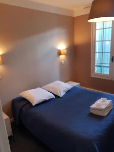 En eller flere senge i et værelse på Hôtel-Restaurant Le Blueberry