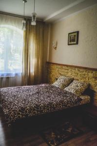 a bedroom with a bed with a brick wall at Lisova Perlina in Volya-Bartativska