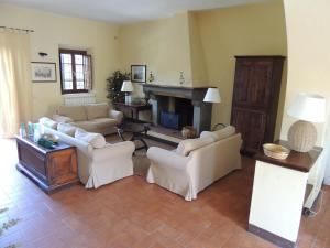 a living room with white furniture and a fireplace at Fattoria di Migliarino in Migliarino