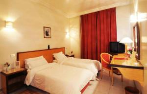 a hotel room with two beds and a desk at Hotel du Parc in Tunis