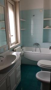 een badkamer met een wastafel, een bad en een toilet bij Letizia's House in Catania