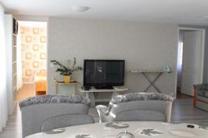 a living room with two chairs and a television at Apartament u Marzenki in Augustów