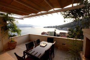 a balcony with a table and chairs and a view of the water at Holiday Home Anna in Klek