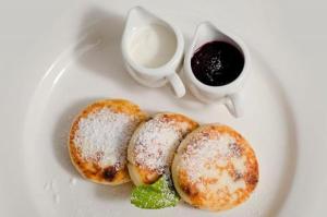 a white plate with three pastries and a cup of coffee at Lisova Perlina in Volya Bortatovska