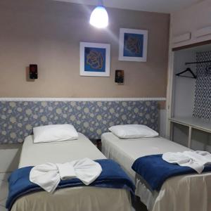 two beds in a hotel room with bows on them at Pousada Convento Da Penha in Vila Velha