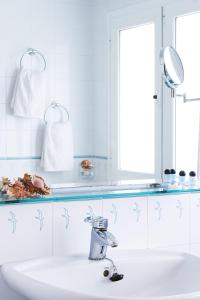 uma casa de banho branca com um lavatório e um espelho em Hotel Miramar Badalona em Badalona