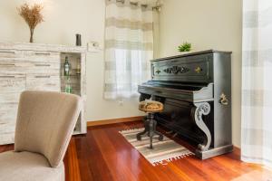 sala de estar con piano y silla en São Félix Ocean Views Apartment, en São Félix da Marinha