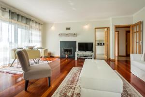 Una sala de estar con un sofá blanco y una mesa. en São Félix Ocean Views Apartment, en São Félix da Marinha