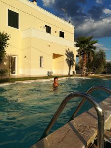 a man in a swimming pool next to a building at La controra in Fasano