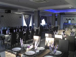 un comedor con mesas y sillas negras y detalles en púrpura en Best Hotel, en Hunedoara