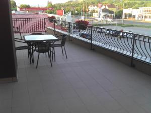 balcón con mesas y sillas y vistas al río en Best Hotel, en Hunedoara