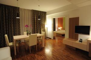 a living room with a dining table and a bedroom at Eureka Palace Hotel Spa Resort in Cassibile
