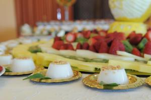 a table topped with plates of cheese and fruit at Eureka Palace Hotel Spa Resort in Cassibile