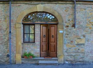 wejście do ceglanego budynku z drewnianymi drzwiami w obiekcie Agriturismo Le Case di San Vivaldo w mieście Montaione