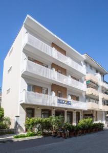 un gran edificio blanco con plantas delante en Hotel Lido, en Grado